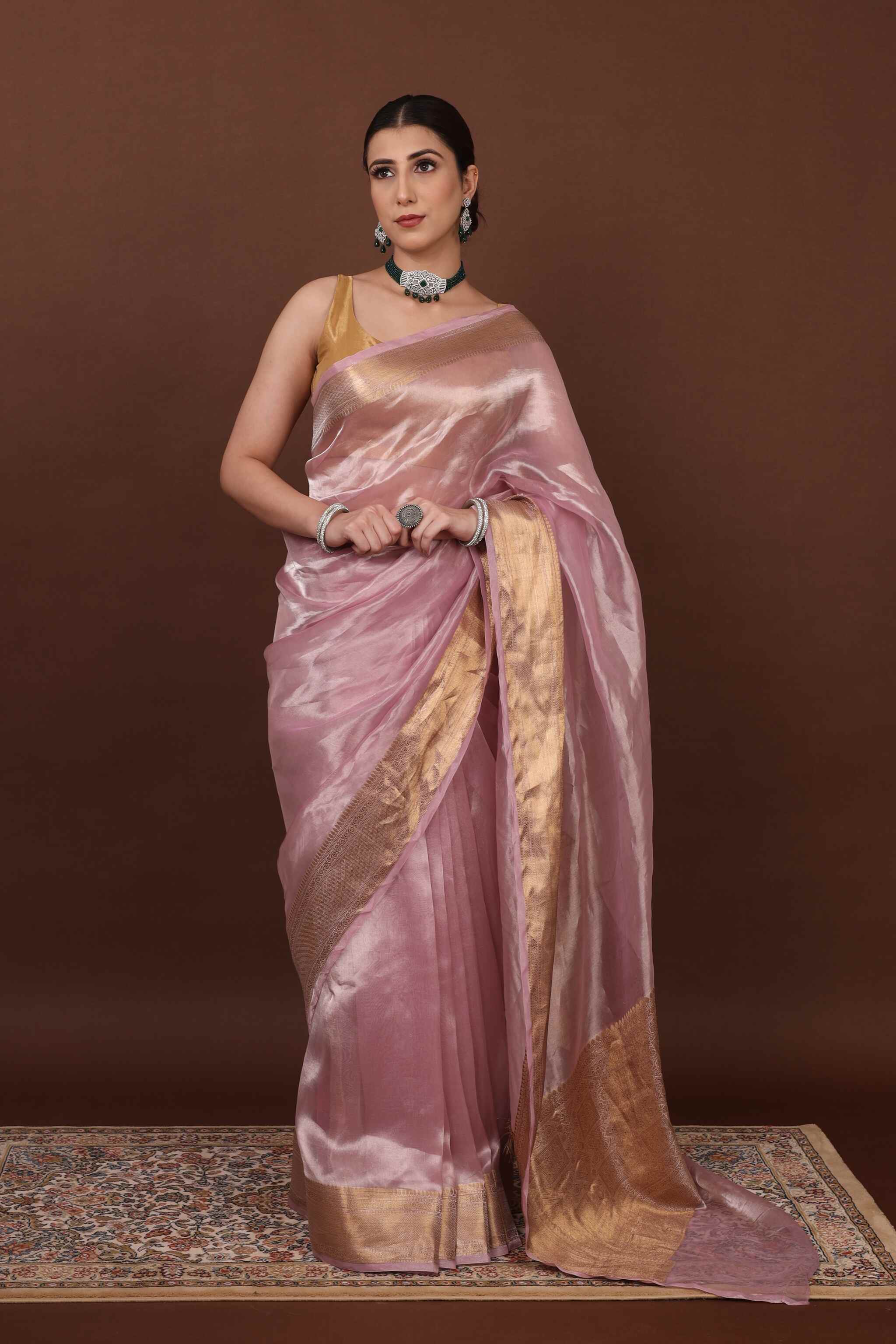 In front view model posing elegantly in pearl pink tissue silk saree