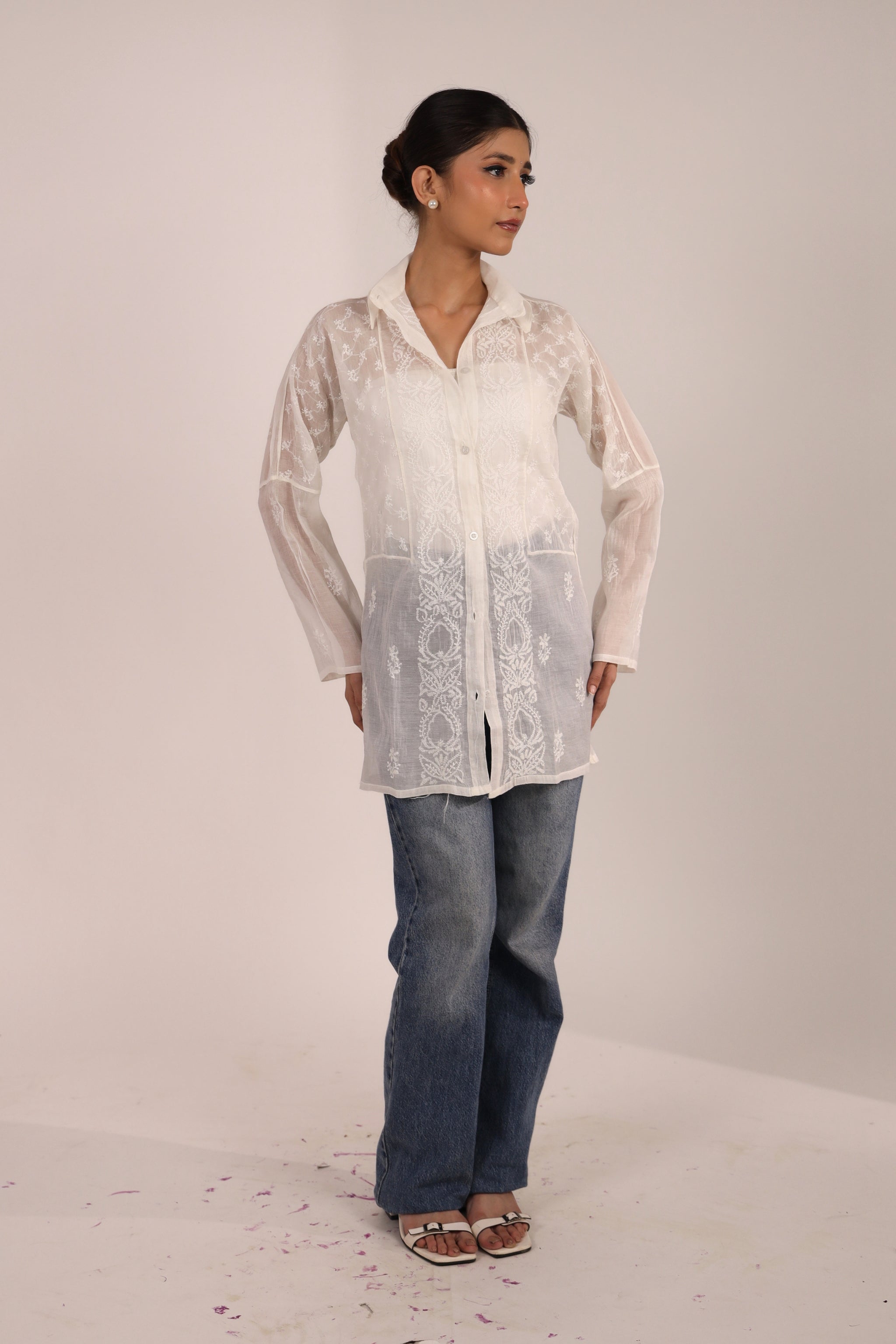 Woman wearing a Chikankar white short kurti for women with a solid background