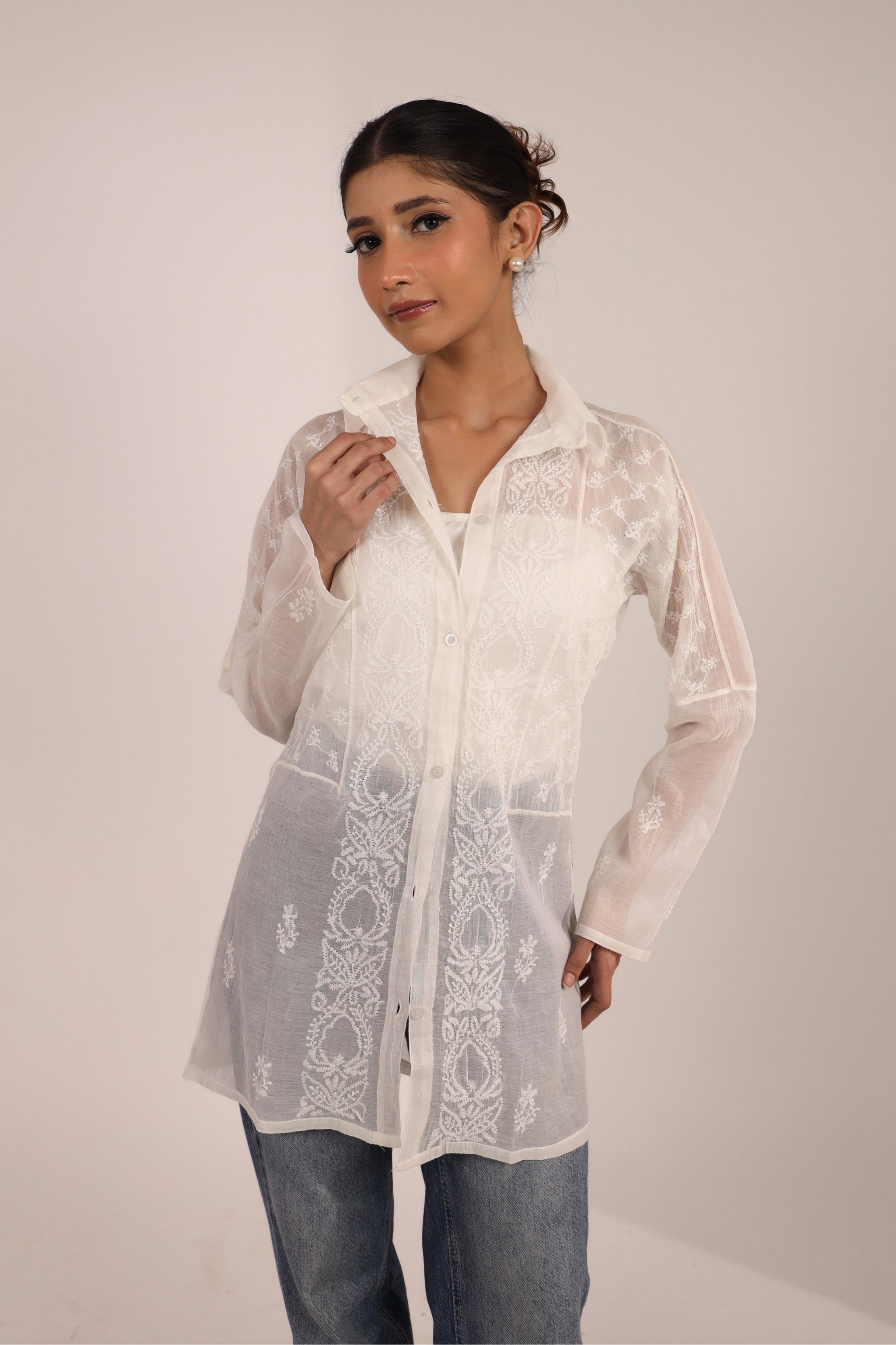 Woman wearing a Chikankari white short kurti for women with jeans and a with solid background