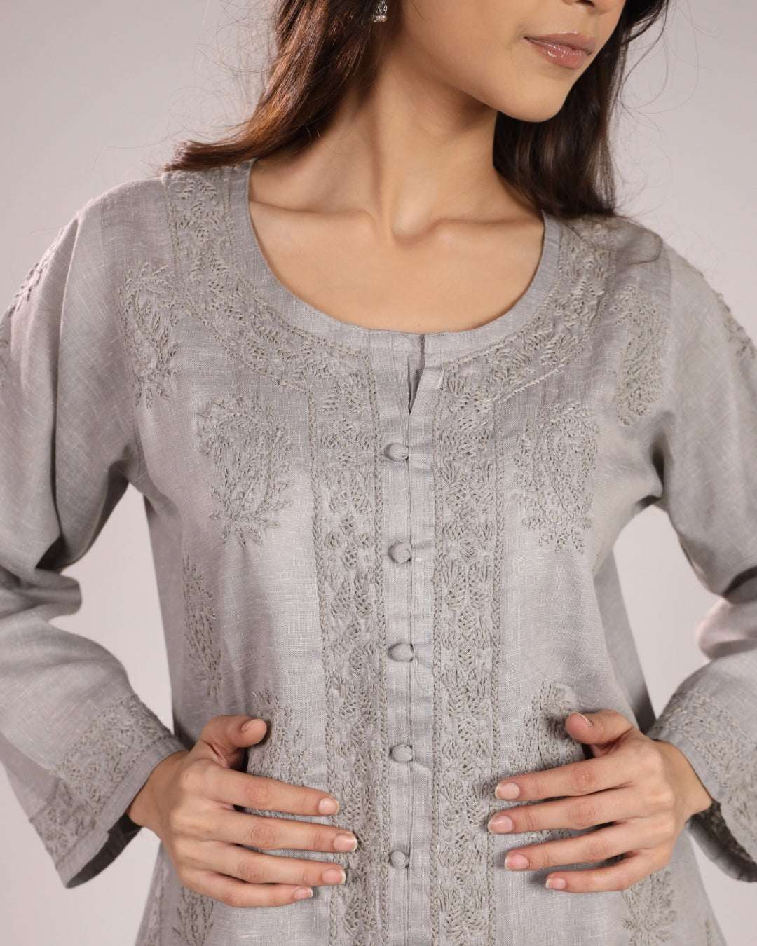 Close up view of grey cotton chikan kurta embroidery with a plain background