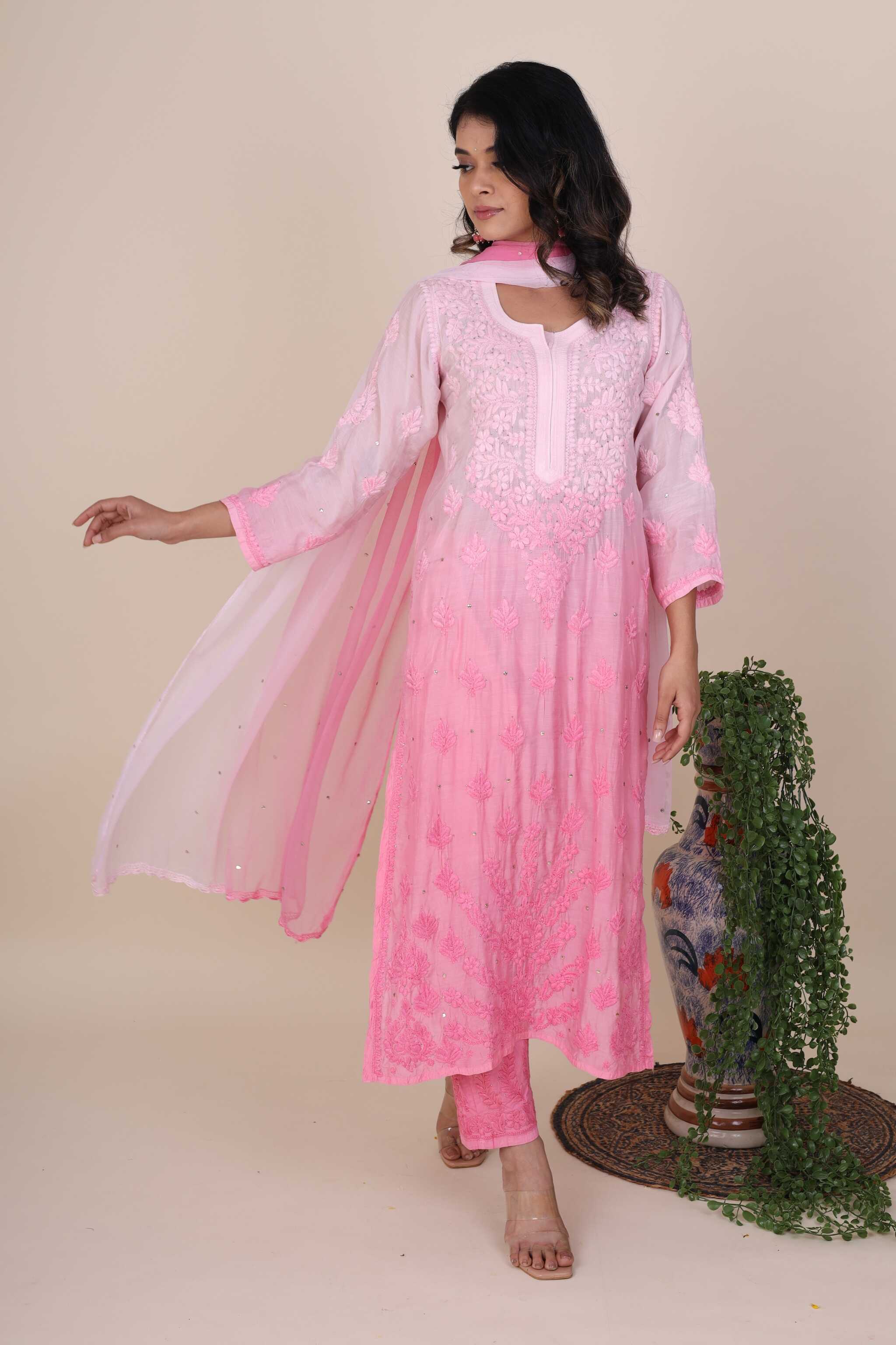 Woman wearing a pink traditional Gulaabo Sangria Chikankari Kurta Set with a sheer dupatta against a beige background