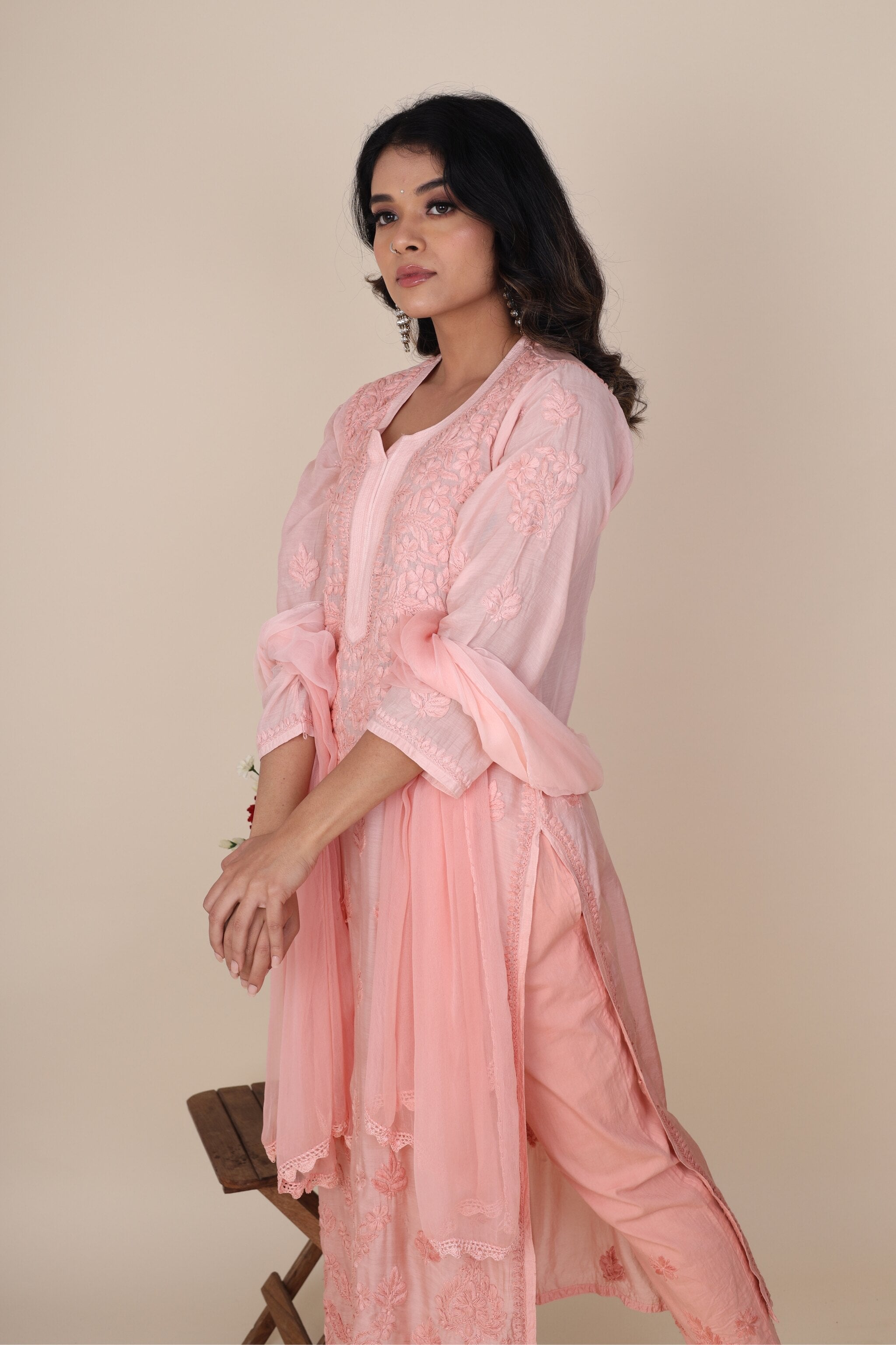 Side pose showcasing chiffon dupatta and elegant muslin kurta in peach fuzz