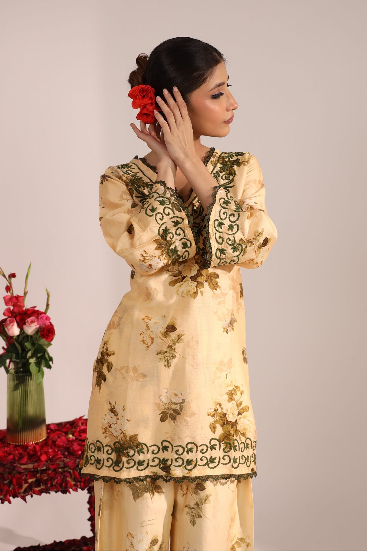 Woman wearing a floral chikankari Chanderi Co-ord Set by House of AKS with a vase of flowers in the background