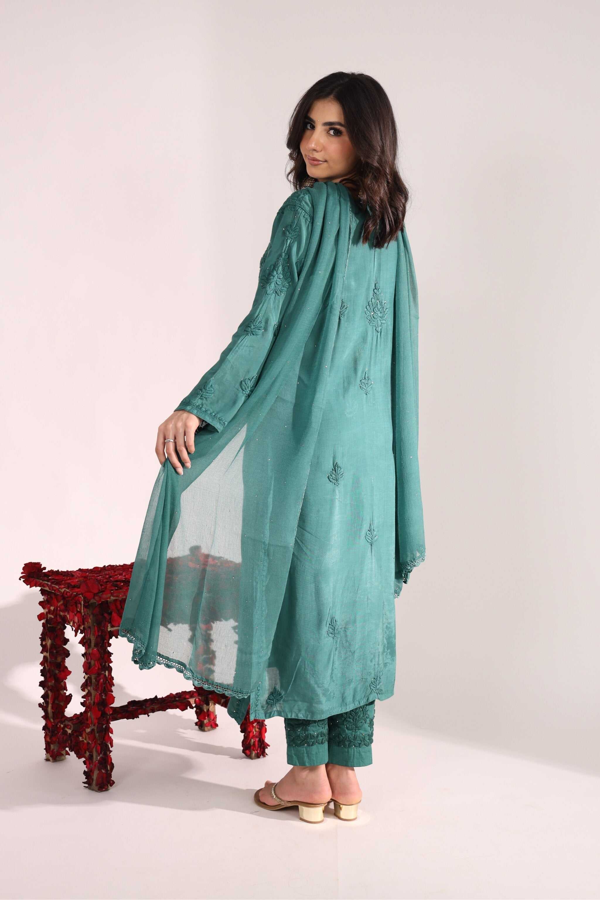 Woman wearing a teal embroidered Sitara Sanchi Chikan Kurta Set with a white background