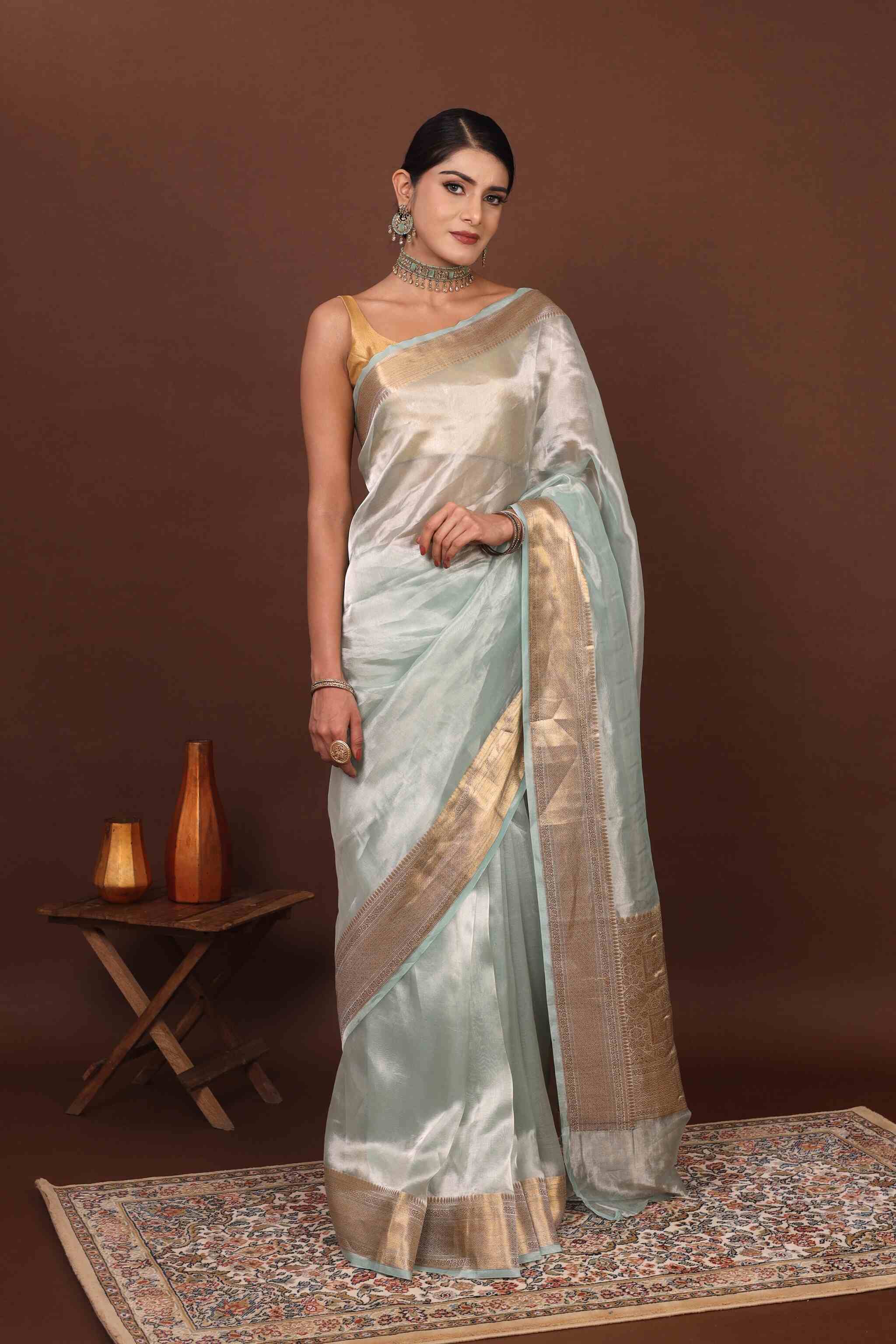 Front view model posing in sea green tissue silk saree