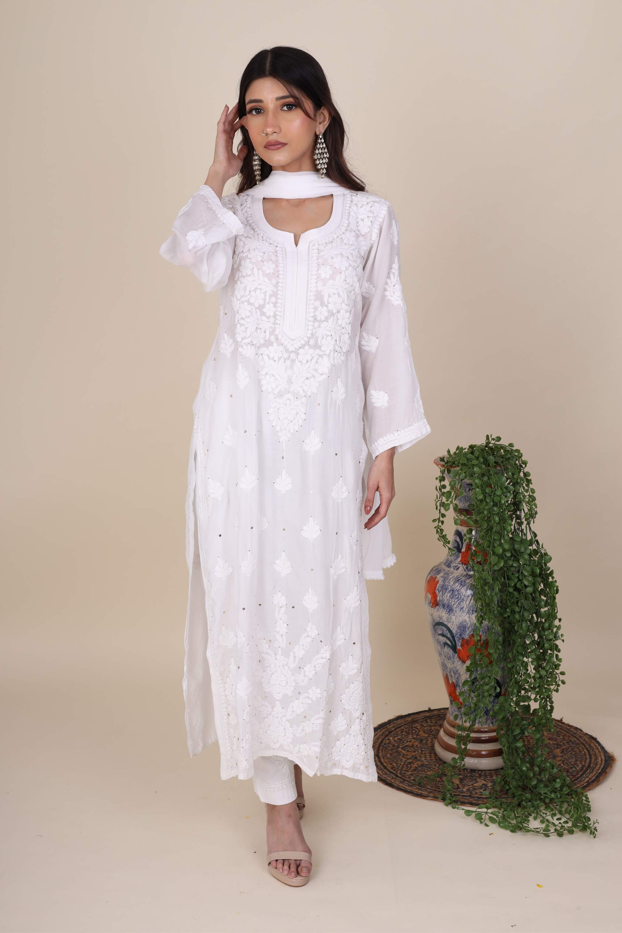 Woman wearing a Gulaabo chikankari Star White Kurta Set with floral patterns against a beige background