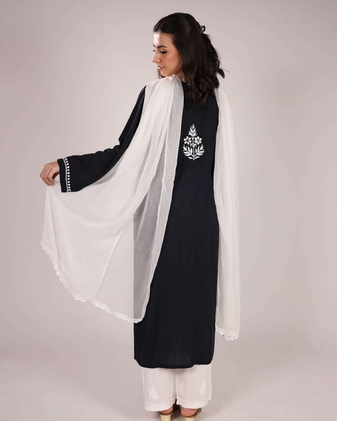 back view of chikankari black kurta with white dupatta on a plain white background