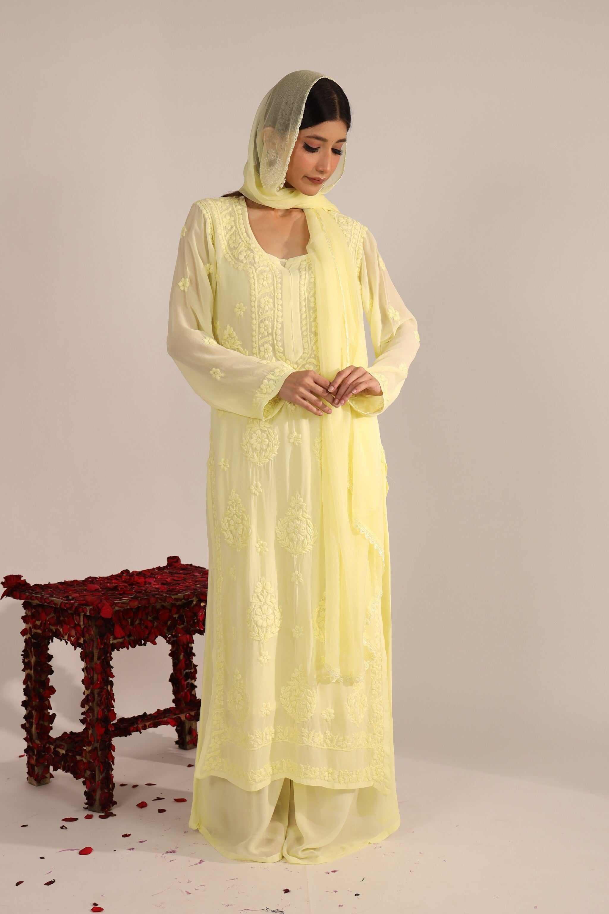 Front View: Woman wearing pastel yellow Georgette Chikankari suit with dupatta – front view.