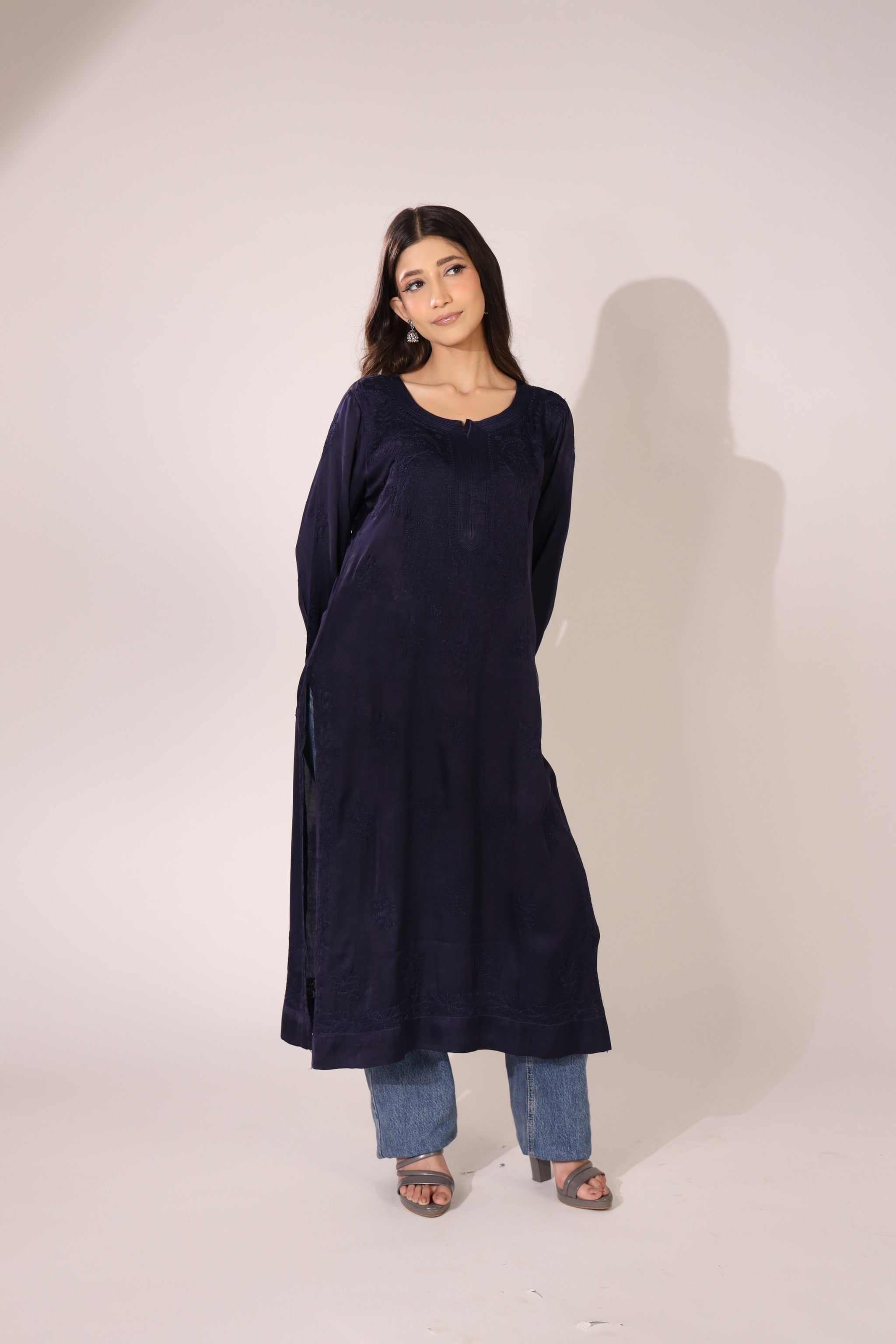 Woman wearing a long straight navy lucknowi kurti against a white background