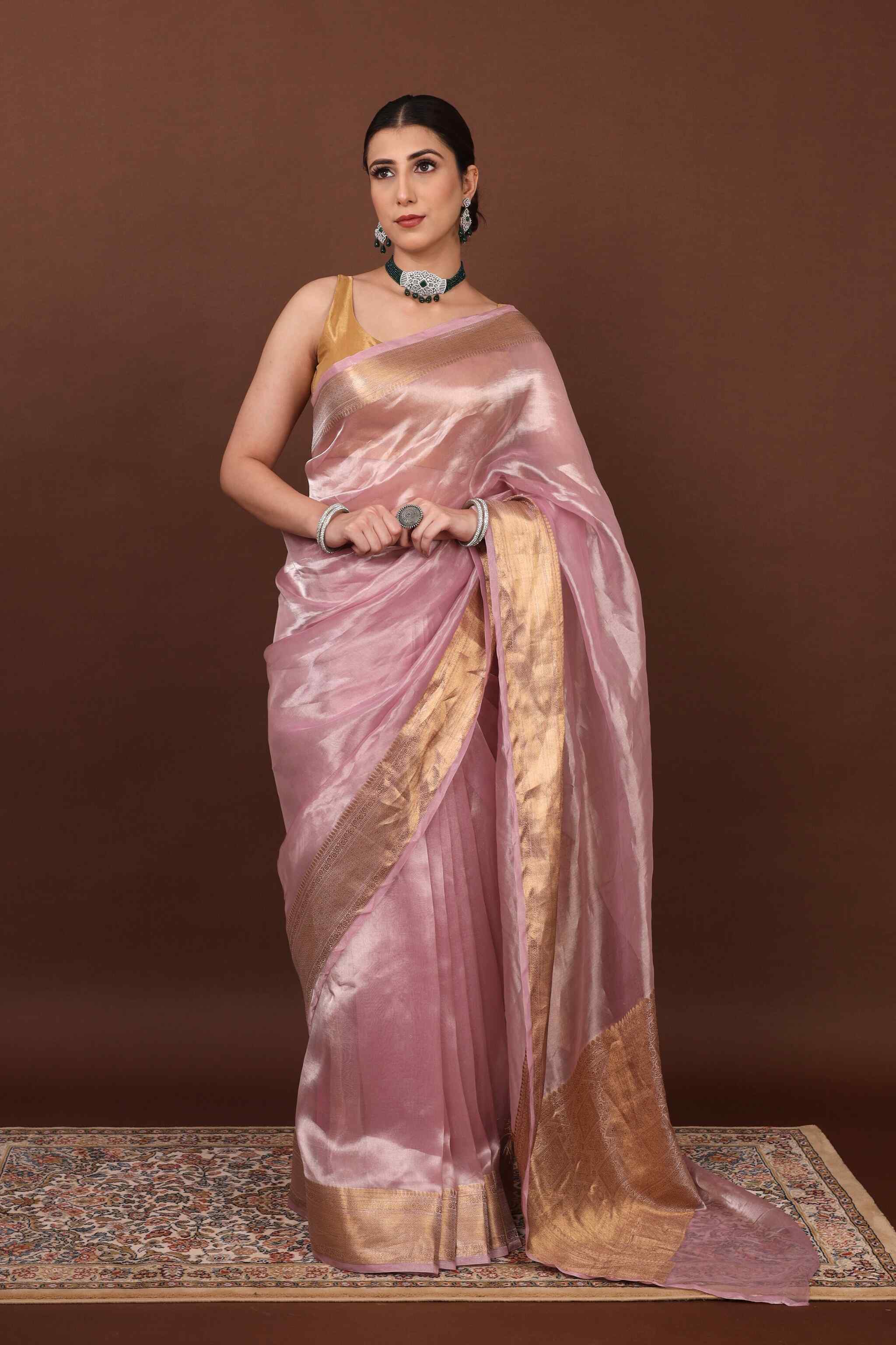 In front view model posing elegantly in pearl pink tissue silk saree 
