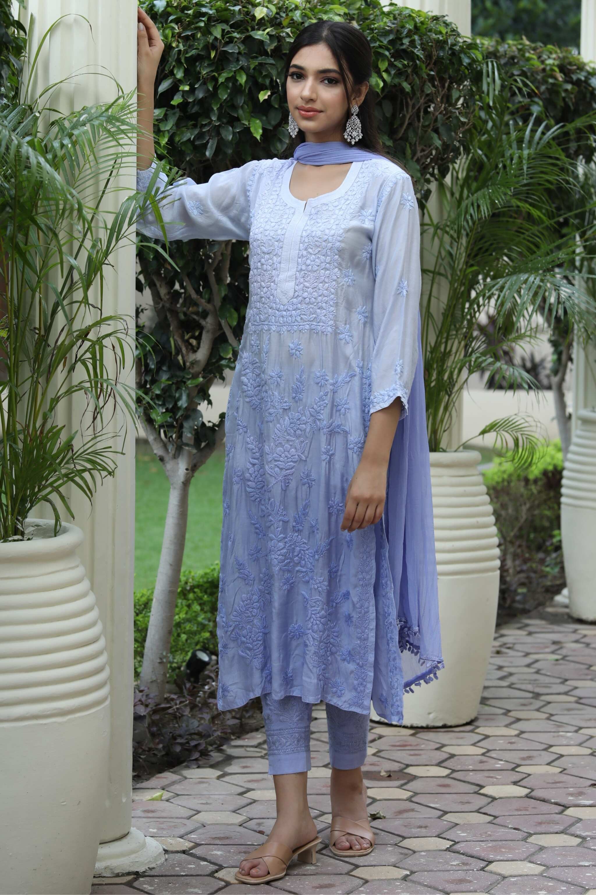 Front view of Gauhar chikasn kurta set in soft muslin cotton with Chikankari embroidery. standing near the piller