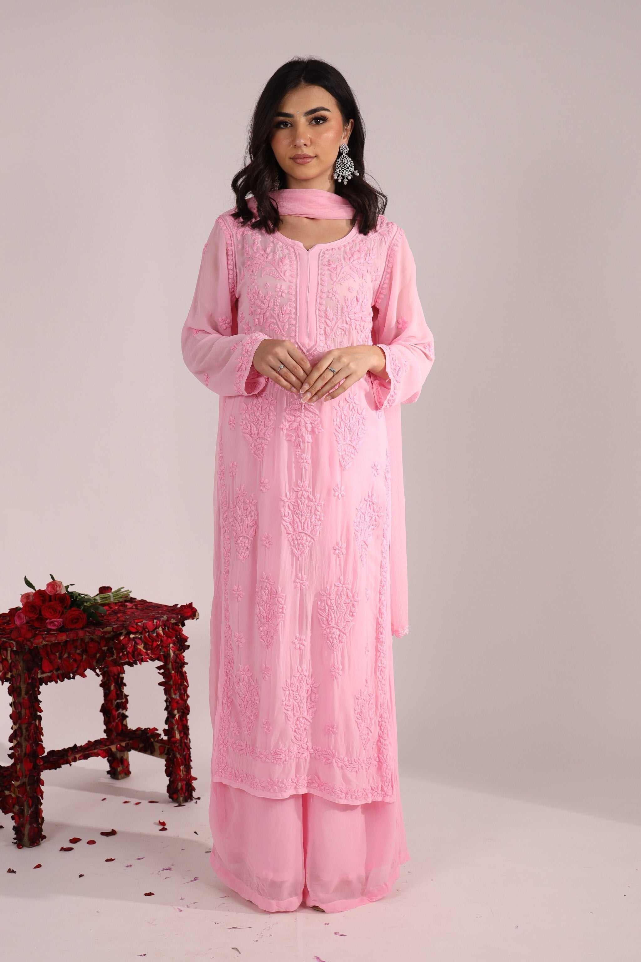 Woman wearing baby pink embroidered kurta and palazzo set from Pari embroidered Suit, standing with poise.