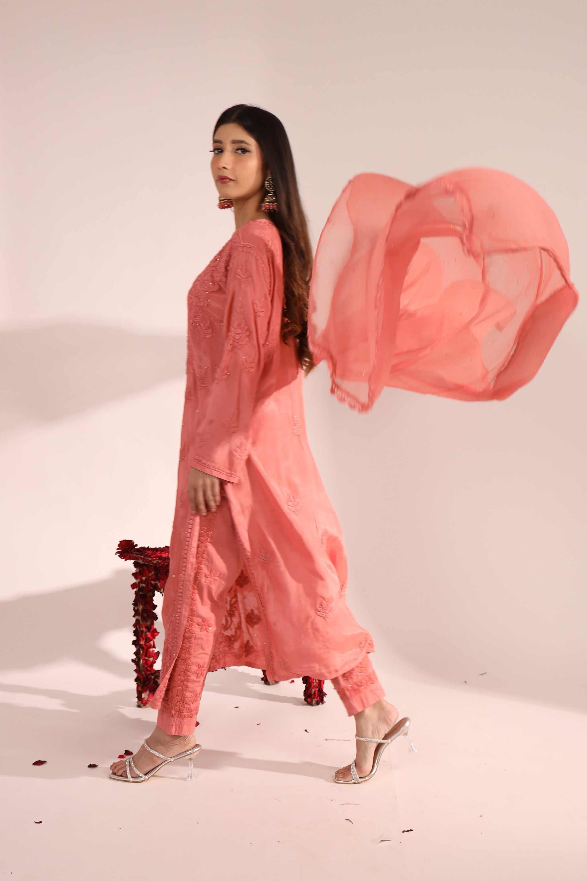 Side profile of the peach bridal kurta set highlighting flowy silhouette and dupatta fall.
