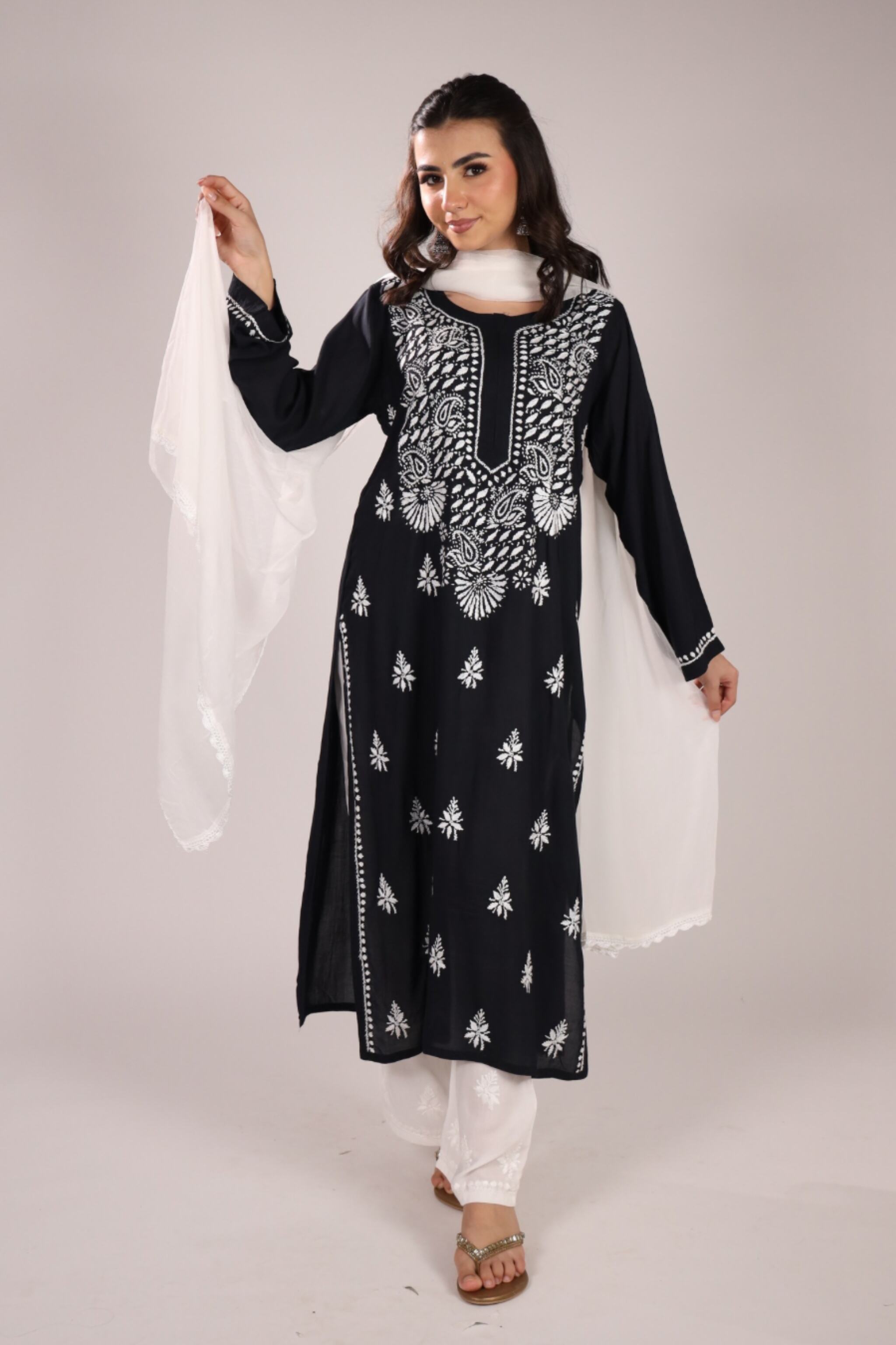 Woman wearing a Chikankari Black Kurta Set with Dupatta with white pants on a plain background