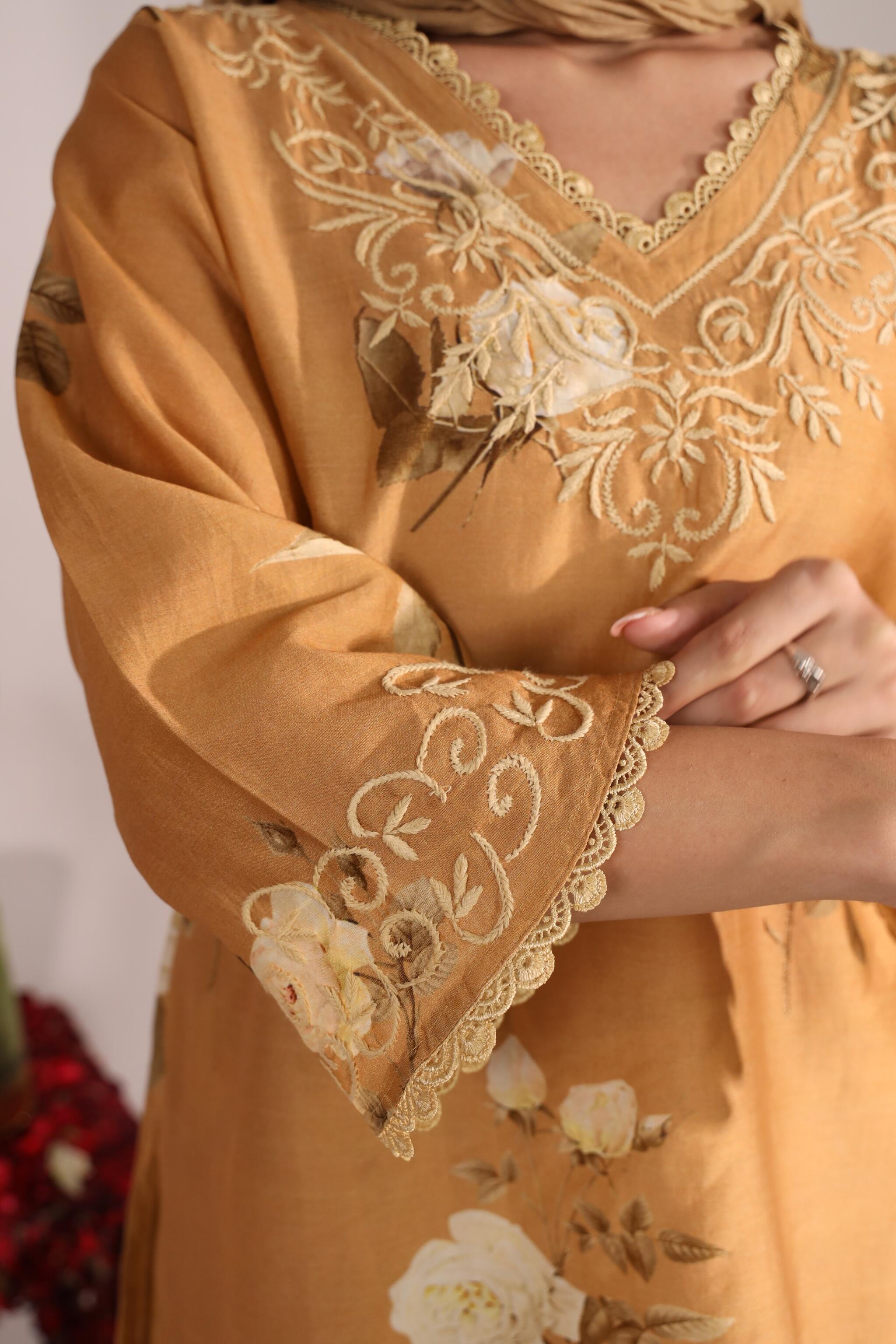 Close-up of a mustard yellow co ord with floral embroidery and lace details.